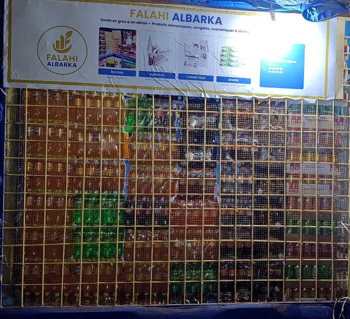 Façade éclairée de la boutique Falahi Albarka, le soir